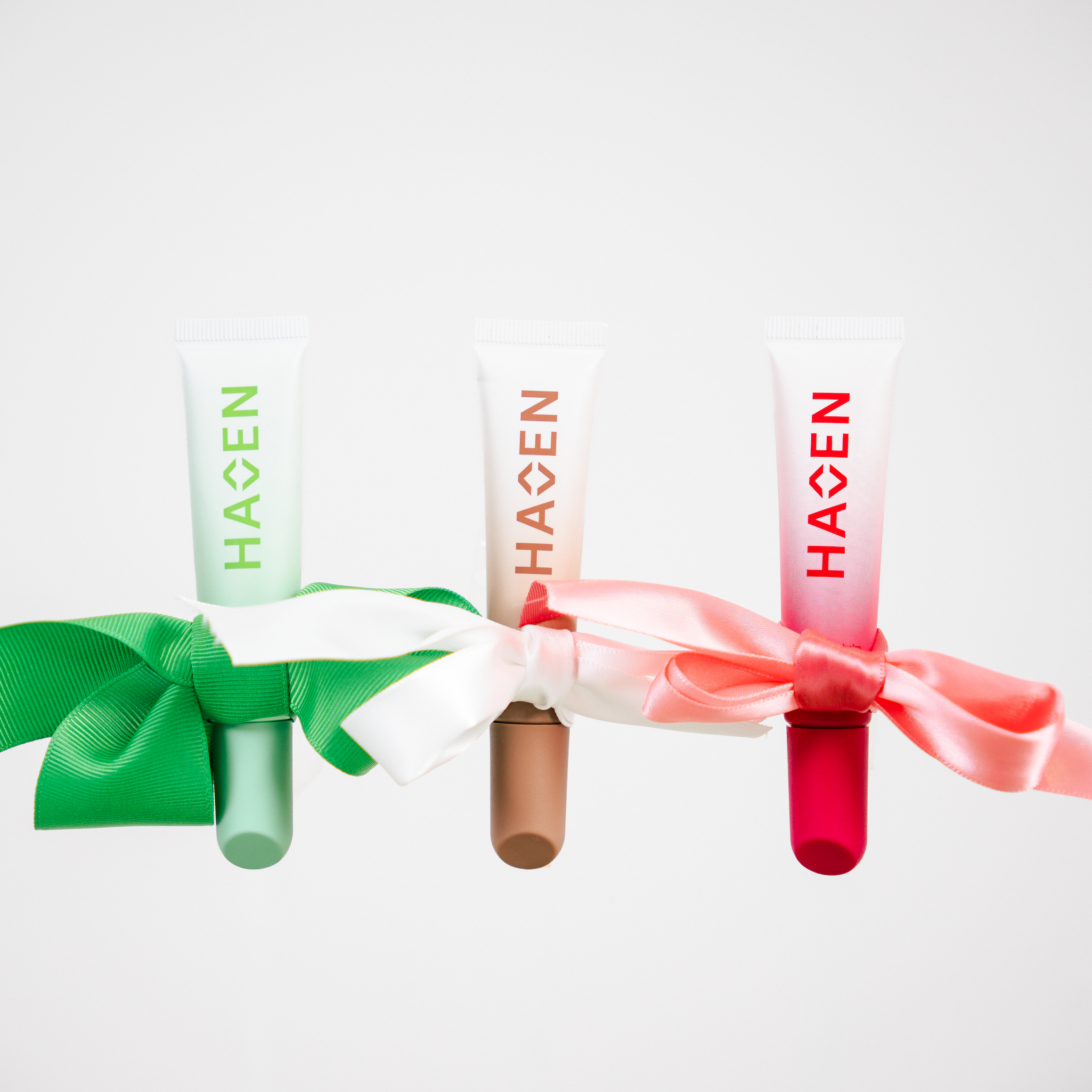 Mint, coconut, and sugar rose lip balms wrapped up in bows.